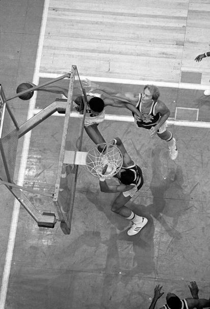 1980, Julius Erving dei Philadelphia 76ers si avvicina a grandi falcate verso il canestro ostacolato da Mark Landsberger e Kareem Abdul-Jabbar dei Los Angeles Lakers (Nba)